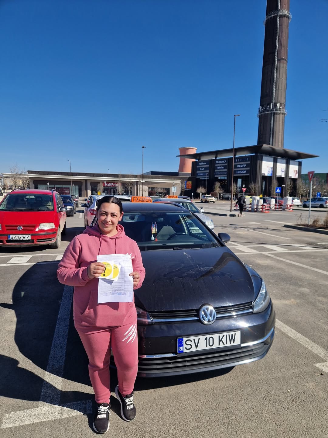 Absolventă AutoStar Drive în zona de examen, lângă mașina de școală