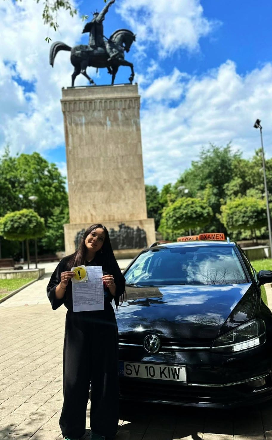 Absolventă AutoStar Drive lângă mașina de școală după examen