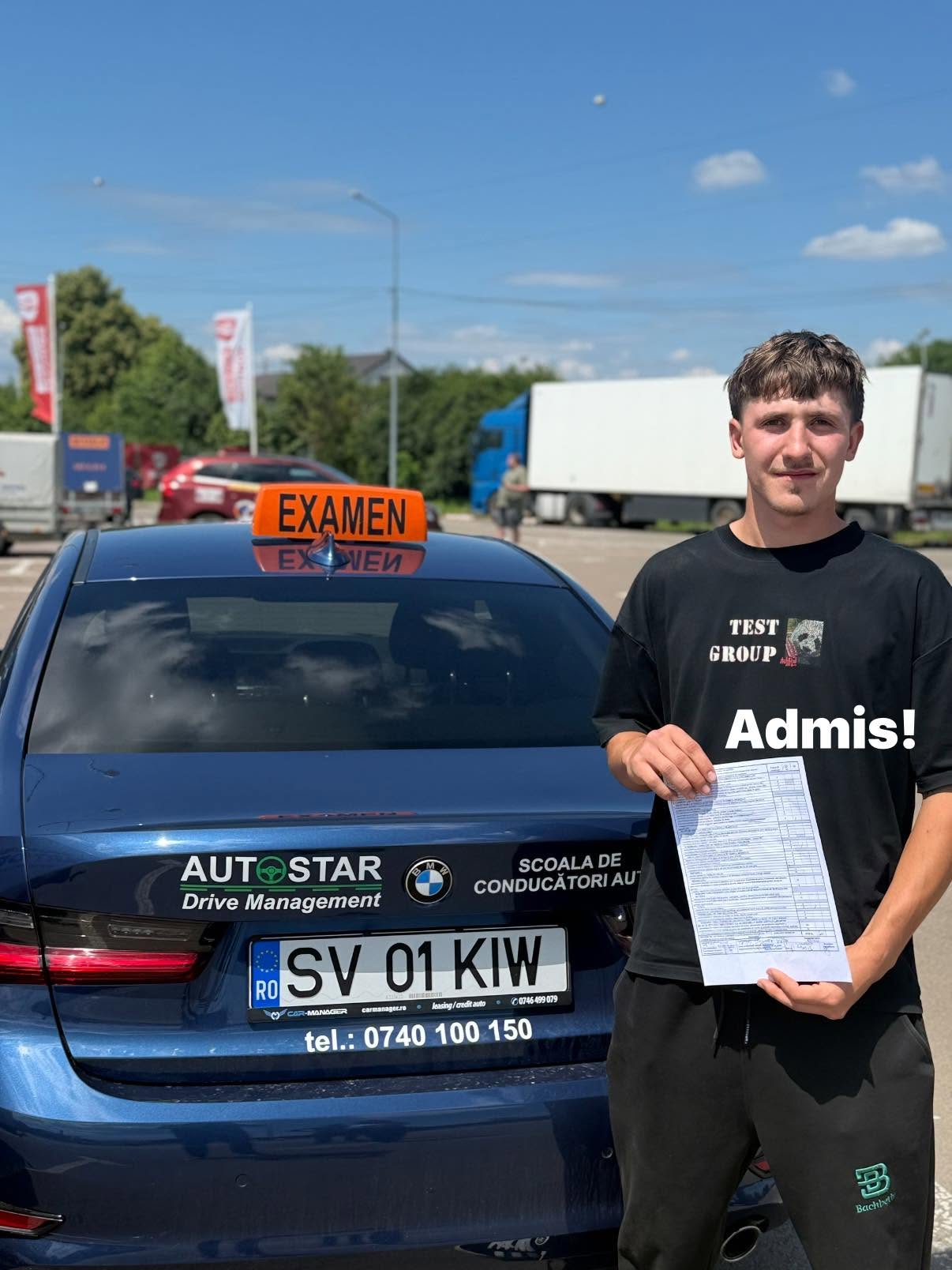 Absolvent AutoStar Drive lângă mașina de școală după examen
