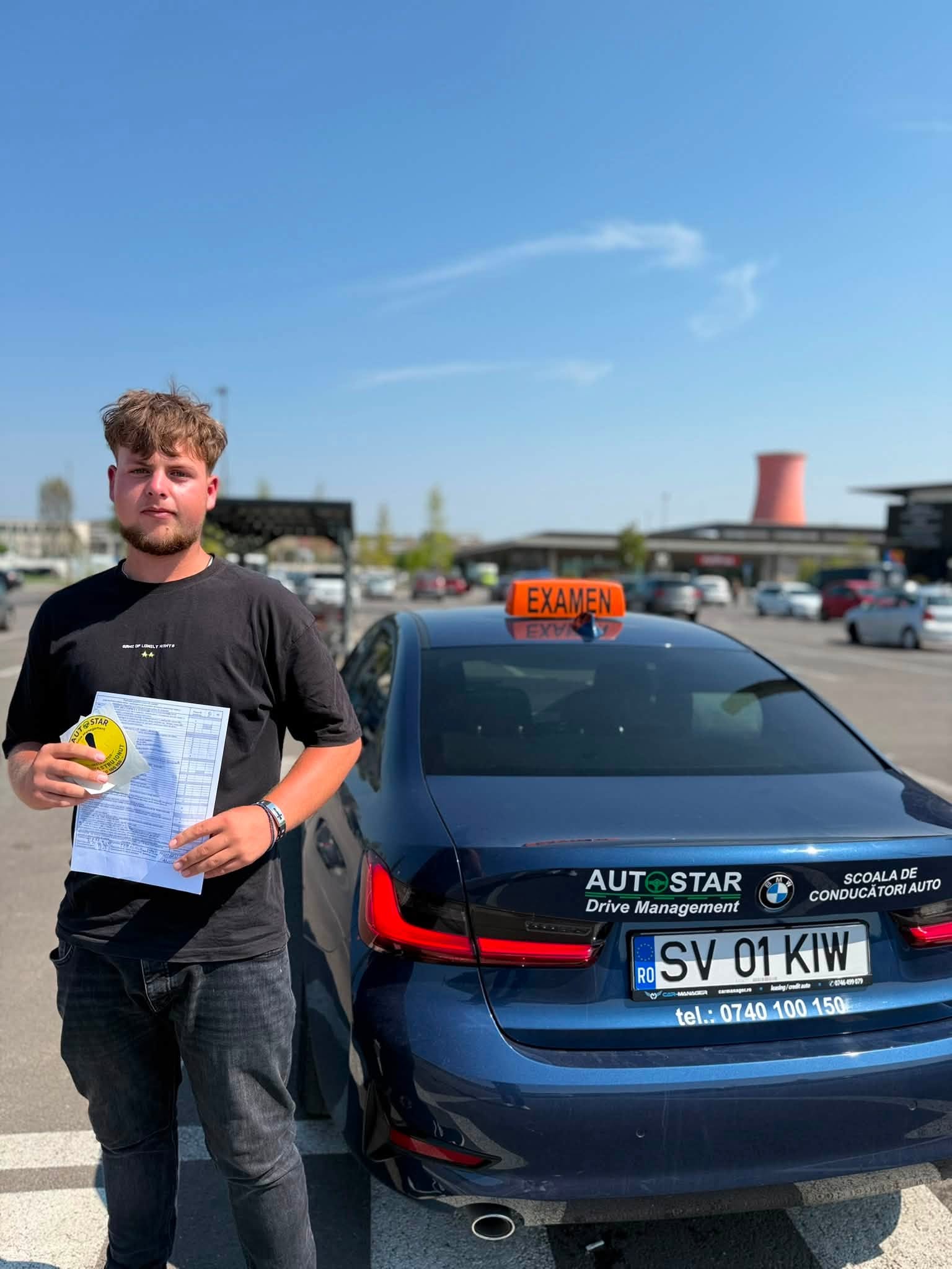 Andrei Tms, absolvent AutoStar Drive, lângă mașina de școală